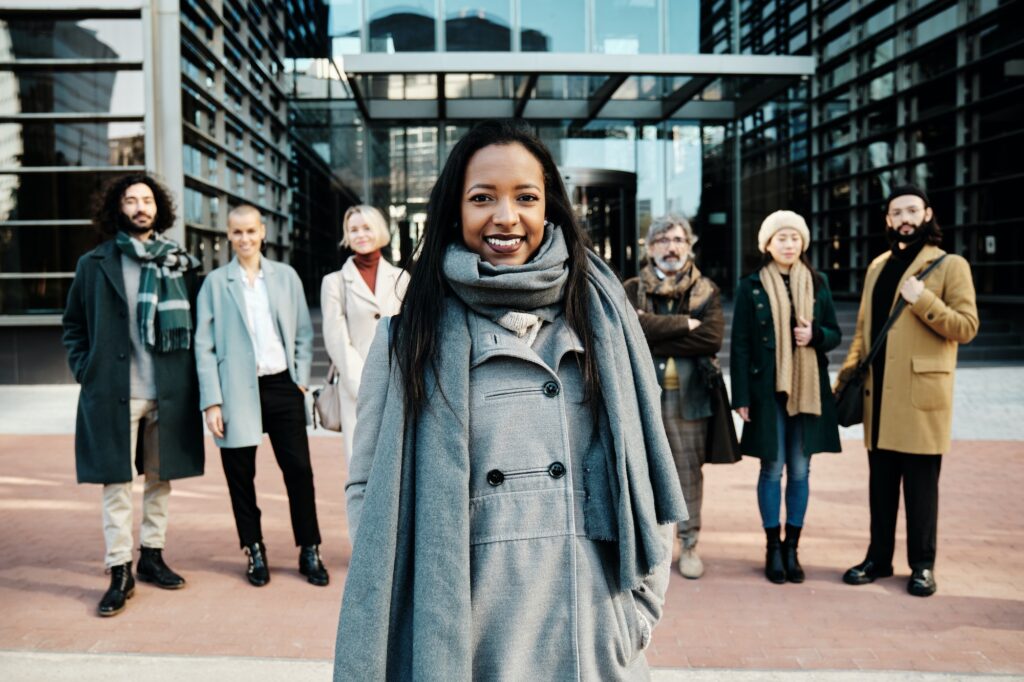 Leading businesswoman standing out from a group of business people while standing together